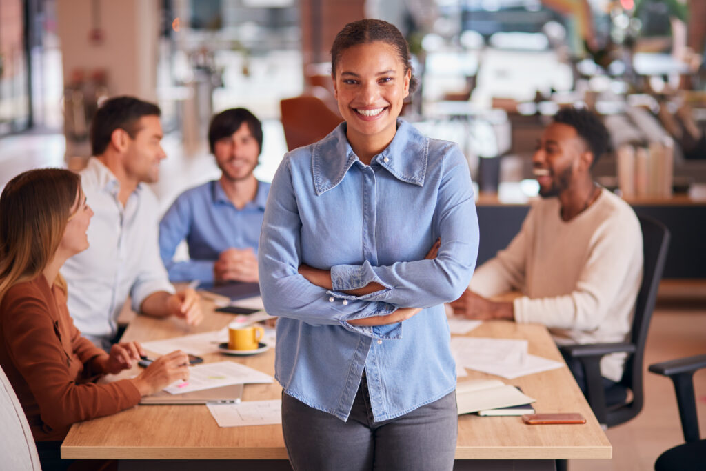 A smiling professional embracing a full-time job in a collaborative workplace.